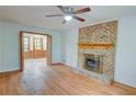 Cozy living room featuring hardwood floors, a brick fireplace with mantle and bi-fold doors to another room at 3352 Northbrook Dr, Atlanta, GA 30340