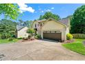 Inviting two-story home featuring lush greenery, a two-car garage, and a welcoming entrance at 3977 Fox Glen Dr, Woodstock, GA 30189