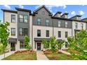 Beautiful view of a new construction white brick townhome with professional landscaping at 445 Breccia Run, Mcdonough, GA 30253