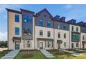Beautiful townhome exhibits modern brickwork, large windows, and simple landscaping, enhancing curb appeal at 445 Breccia Run, Mcdonough, GA 30253