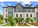 Beautiful view of a new construction white brick townhome with professional landscaping at 445 Breccia Run, Mcdonough, GA 30253