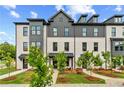 Beautiful view of a new construction white brick townhome with professional landscaping at 445 Breccia Run, Mcdonough, GA 30253