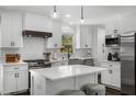 Modern kitchen with white cabinets, stainless steel appliances, a center island, and a stylish backsplash at 1055 Delmont Ter, Roswell, GA 30075