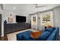 Bright living room with a large sofa, sleek entertainment center, and ample natural light from the windows at 1055 Delmont Ter, Roswell, GA 30075