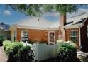 Brick home featuring a chimney, manicured landscaping, and a white picket fence at 2191 Rockbridge Rd # 103, Stone Mountain, GA 30087