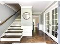 Entryway featuring hardwood floors, white trim, staircase, and a doorway with glass french doors at 3707 Dunwoody Club Dr, Atlanta, GA 30350