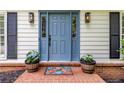 Close-up of a charming blue front door with sidelights, potted plants, and a colorful welcome mat at 3707 Dunwoody Club Dr, Atlanta, GA 30350