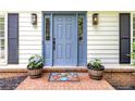 Close-up of a light blue front door flanked by black shutters and potted plants on a brick porch at 3707 Dunwoody Club Dr, Atlanta, GA 30350