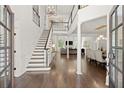 Bright foyer with hardwood floors, staircase, and views to a dining room and living room beyond at 5120 Falcon Chase Ln, Atlanta, GA 30342
