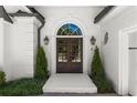 Close-up of a home's double front door, adorned with elegant lighting and manicured greenery at 5120 Falcon Chase Ln, Atlanta, GA 30342
