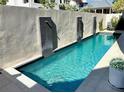 Stunning backyard pool featuring modern waterfalls and ample space for relaxation and entertaining friends at 11260 Serenbe Ln, Chattahoochee Hills, GA 30268