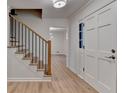 Bright foyer featuring wood-look floors, stairs with black iron railings, and white trim at 315 N Fayette Dr, Fayetteville, GA 30214
