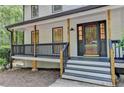Inviting front porch with black railings and natural wood posts, a cozy entryway at 315 N Fayette Dr, Fayetteville, GA 30214