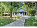 Beautiful front exterior featuring a well-maintained lawn, mature trees, and a charming, freshly painted facade at 1207 Ellington Dr, Morrow, GA 30260