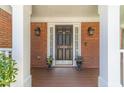 Elegant front door with decorative details, sidelights, and black planters at 4610 Admiral Ridge Way, Lilburn, GA 30047