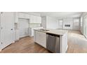 Open kitchen design with a kitchen island, stainless dishwasher, and a combined living and dining area at 7175 Brushwood Bend - Lot 36, Lithonia, GA 30058