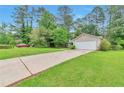 Exterior view of a house with a long driveway, a two-car garage and trees in the background at 744 Martin Rd, Stone Mountain, GA 30088