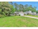 Exterior view of a house with a well-maintained lawn, a two-car garage and other houses nearby at 744 Martin Rd, Stone Mountain, GA 30088