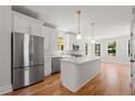 Modern kitchen with stainless steel appliances, white cabinetry, quartz countertops, and a kitchen island at 110 Hogue St, Atlanta, GA 30312
