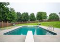 Backyard featuring a refreshing in-ground pool, diving board, ladder, and lush landscaping for outdoor enjoyment at 409 Cold Springs Ln, Mcdonough, GA 30252