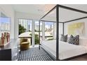 Bright bedroom with a canopy bed, a view of buildings through large windows, and modern décor at 775 Juniper St # 405, Atlanta, GA 30308