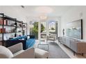 Bright living room with stylish blue sofa, modern shelving unit, and large windows showcasing city views at 775 Juniper St # 405, Atlanta, GA 30308