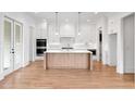 Modern kitchen with a large island, hardwood floors, and stainless steel appliances at 002 Wakehurst Way, Marietta, GA 30064