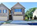 Charming townhome featuring a brick facade, attached garage, and well-maintained landscaping at 4421 Fulson Dr, Lilburn, GA 30047
