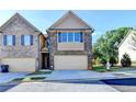 Charming townhome featuring a brick facade, attached garage, and well-maintained landscaping at 4421 Fulson Dr, Lilburn, GA 30047