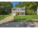 Charming two-story home with a well-manicured lawn, covered porch, and attached garage at 6223 Marbut Farms Ln, Lithonia, GA 30058