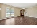 Bright living room featuring hardwood floors, a staircase, and a decorative front door at 6223 Marbut Farms Ln, Lithonia, GA 30058
