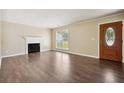 Bright living room featuring hardwood floors, a fireplace, and a decorative front door at 6223 Marbut Farms Ln, Lithonia, GA 30058