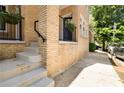Apartment exterior with stairs, yellow brick, black railings, and hanging plants at 653 N Highland Ne Ave # 5, Atlanta, GA 30306