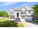 Attractive two-story home with gray siding, black shutters, a well-kept lawn, and an attached one-car garage at 7186 Raintree Loop, Jonesboro, GA 30236