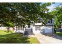 Well-kept two story home features a driveway, lawn, black shutters, and classic architectural details at 7186 Raintree Loop, Jonesboro, GA 30236