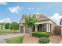 Charming home featuring a brick driveway, two-car garage, and well-maintained front yard at 308 Rusty Gate Pass, Woodstock, GA 30189
