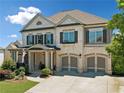 Charming two-story home with white brick, shuttered windows, and two-car garage at 4440 Atwood Dr, Cumming, GA 30040