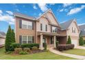 Inviting two-story home with a covered front porch, lush landscaping, and a charming neighborhood ambiance at 651 Deer Springs Way, Loganville, GA 30052