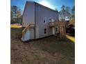 Back of a two-story house with gray siding, deck, walkout basement, and sloped backyard at 192 Paces Lakes Pt, Dallas, GA 30157