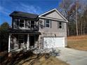 Charming two-story home with gray siding, brick accents, a covered porch, and a two-car garage at 192 Paces Lakes Pt, Dallas, GA 30157