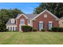 Traditional brick and siding home with a well-manicured lawn and mature landscaping at 2525 Highbrooke Trl, Duluth, GA 30097