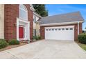 Traditional home featuring a red front door, brick accents, and a two-car garage at 2525 Highbrooke Trl, Duluth, GA 30097