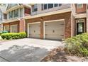 A close view of townhome garages with brick accents and a paved driveway at 2957 Smith Ridge Trce, Peachtree Corners, GA 30071