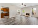 Open-concept living room with hardwood floors, fireplace, and a view of the kitchen at 2957 Smith Ridge Trce, Peachtree Corners, GA 30071