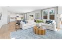 Inviting living room featuring a plush sectional sofa, stylish rug, and an open layout to the kitchen at 7169 Brushwood Bend - Lot 37, Lithonia, GA 30058