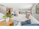 Open-concept living room showcases a comfortable white sectional sofa, round coffee table, and modern decor at 7169 Brushwood Bend - Lot 37, Lithonia, GA 30058