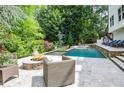Backyard oasis features a luxurious pool, fire pit, and lounge area at 965 Tiverton Ln, Alpharetta, GA 30022