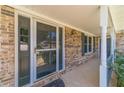 Inviting entryway featuring a brick facade, covered porch, and decorative door with sidelights at 5166 Vivid Dr, Stone Mountain, GA 30087