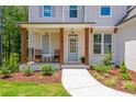 Inviting front porch with rocking chairs and sturdy wooden posts welcomes visitors to this charming home at 1013 Liberty Springs Dr, Woodstock, GA 30188