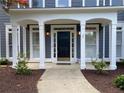 Inviting home entrance featuring a covered porch, well-defined columns, and manicured landscaping at 219 Maple Creek, Woodstock, GA 30188